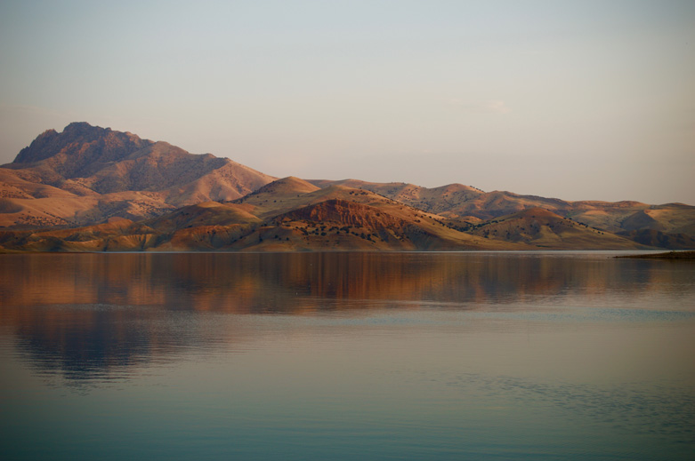 The man-made lake at Dukan is still and mirror-like at sunrise.